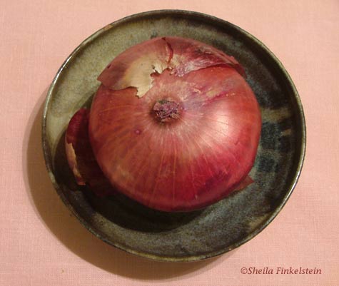 red onion starting to peel in a pottery dish made by Sheila Finkelstein